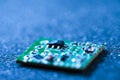 Closeup Macro Shot of Miniature Printed Circuit Board Against Blue Material Surgace with Surface Mounted Components