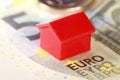 Closeup macro shot of a real estate house figurine on top of a euro banknote Royalty Free Stock Photo