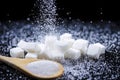 Closeup Macro Shot of White Cube Sugar And Falling Sand Sugar Along With Filled Wooden Measure Spoon. Against Black Background Royalty Free Stock Photo