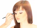 Closeup.Makeup artist applies eye shadow. Beautiful woman face Royalty Free Stock Photo