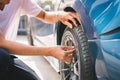 Closeup male automotive technician removing tire valve nitrogen cap for tire inflation service at garage or gas station. Car