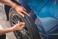 Closeup male automotive technician removing tire valve nitrogen cap for tire inflation service at garage or gas station. Car Royalty Free Stock Photo