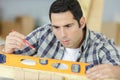 Closeup male carpenter using level on wood board Royalty Free Stock Photo