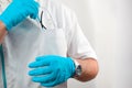 Closeup of a male dentist putting his working glasses in his uniform's pocket