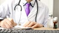 Closeup of male doctor hand writing a medical prescription Royalty Free Stock Photo
