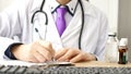 Closeup of male doctor hand writing a medical prescription Royalty Free Stock Photo