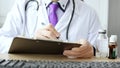 Closeup of male doctor hand writing a medical prescription Royalty Free Stock Photo