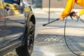 Closeup of male driver washing his car with contactless high pressure water jet in self service car wash Royalty Free Stock Photo