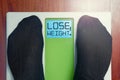 Closeup male feet on scale at morning lose weight words