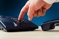 Closeup of male finger pressing a button on landline telephone Royalty Free Stock Photo