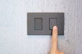 Closeup Male finger is turn on or off on light switch on wall at home. Energy Saving, power, electrical and lifestyle concepts Royalty Free Stock Photo