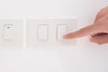 Closeup Male finger is turn on or off on light switch on white wall at home. Energy Saving, power, electrical and lifestyle Royalty Free Stock Photo