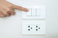 Closeup Male finger is turn on or off on light switch on white wall at home. Energy Saving, power, electrical and lifestyle Royalty Free Stock Photo