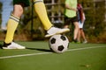 Closeup male foot in boots on soccer ball over green grass field Royalty Free Stock Photo