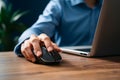 Closeup Male hand clicks wireless digital mouse at office desk Royalty Free Stock Photo