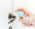 Closeup of a male hand disinfecting the door with an antibacterial - detail of caucasian hand cleaning the house handle