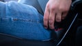 Closeup of a male hand fastening the seat belt on before driving a car