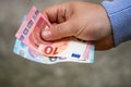 Closeup of a male hand giving Euro banknotes - world money, inflation and economy concept Royalty Free Stock Photo