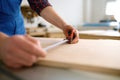 Closeup male hand measuring wooden board making furniture wooden blank Royalty Free Stock Photo