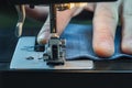 Closeup Male Hand Sewing Denim On A Sewing Machine. Worker Clothes. Macro Shooting. Sewing Still Life