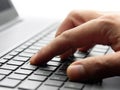 Closeup male hand typing keyboard computer laptop backlit Royalty Free Stock Photo