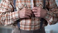 Closeup of male hands buttoning up checkered shirt, old-fashioned clothes