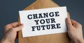 Closeup of a male hands holding craft envelope with text Change your future on blue background Royalty Free Stock Photo