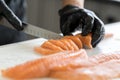 Closeup male hands slicing salmon. Chef cutting fresh fish. A worker cutting salmon on a board Royalty Free Stock Photo