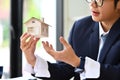 Closeup male realtor holding a house model. Buying property, real estate, loan and insurance Royalty Free Stock Photo