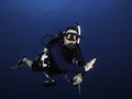 Closeup of a male scuba diver in the deep blue sea looking at the camera Royalty Free Stock Photo