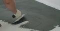 Closeup male worker applying micro concrete plaster coating on the floor with a trowel Royalty Free Stock Photo