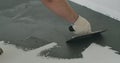 Closeup male worker applying micro concrete plaster coating on the floor with a trowel Royalty Free Stock Photo