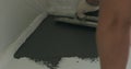 Closeup male worker applying micro concrete plaster coating on the floor with a trowel