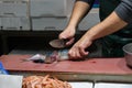 Closeup of male worker& x27;s hands cutting fish with knife at table Royalty Free Stock Photo