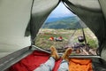 Closeup of man in camping tent with sleeping bags on mountain hill