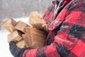 Closeup of man carrying bundle of firewood through the snow Royalty Free Stock Photo