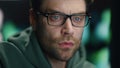 Closeup man coder working night datacenter. Serious developer looking computer Royalty Free Stock Photo