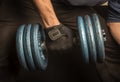 Home: Close up of a man doing rows with a blue dumbbell. 9