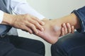 Closeup of Man feeling pain in her foot and doctor the traumatologist examines or treatment on white background, Healthy concept Royalty Free Stock Photo