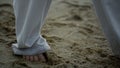 Man feet taking steps on sand closeup. Barefoot sportsman training on beach. Royalty Free Stock Photo
