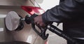 Closeup of man filling benzine gasoline fuel in car at gas station. African American Man Refueling Car At Gas Station