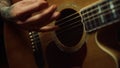 Unrecognizable person playing acoustic guitar in dark recording studio. Royalty Free Stock Photo