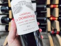 Closeup of Man hand buying a Saint-Emilion Classified Growth bottle, a great French bordeaux wine in supermarket Royalty Free Stock Photo