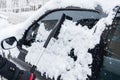 Closeup of man hand clean snow from parked car with cleaning brush cold winter day