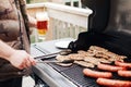 Closeup of man hand holding glass with fresh beer. Man grilling roasting meat chicken breasts and meat sausages barbeque on Royalty Free Stock Photo