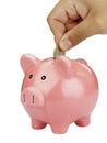 Closeup of man hand inserting coin in piggybank isolated on white