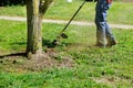 Closeup man hand using lawn trimmer mower cutting grass on green selective focus at hand Royalty Free Stock Photo