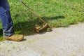 Closeup man hand using lawn trimmer mower cutting grass on green selective focus at hand Royalty Free Stock Photo