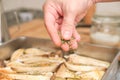 Closeup of man hands adding oregano over sliced king trumpet mushrooms pleurotus eryngii, potatoes and onions Royalty Free Stock Photo