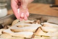 Closeup of man hands adding salt over sliced king trumpet mushrooms pleurotus eryngii, potatoes and onions Royalty Free Stock Photo